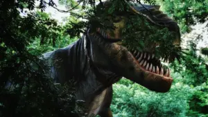 Didelis ir tikroviškas dinozauras tyko tankioje miško žalumoje, atrodantis labai įspūdingai.